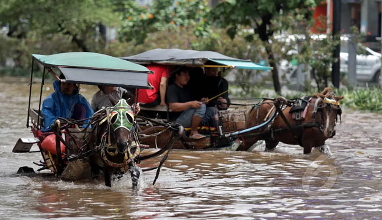 Penumpang menggunakan jasa delman untuk menembus banjir di kawasan Kelapa Gading, Jakarta, Selasa (10/2). Hujan yang mengguyur Jakarta sejak Minggu (8/2) lalu mengakibatkan sejumlah jalan banjir dan tak bisa dilalui kendaraan. (Liputan6.com/Faizal Fanani)