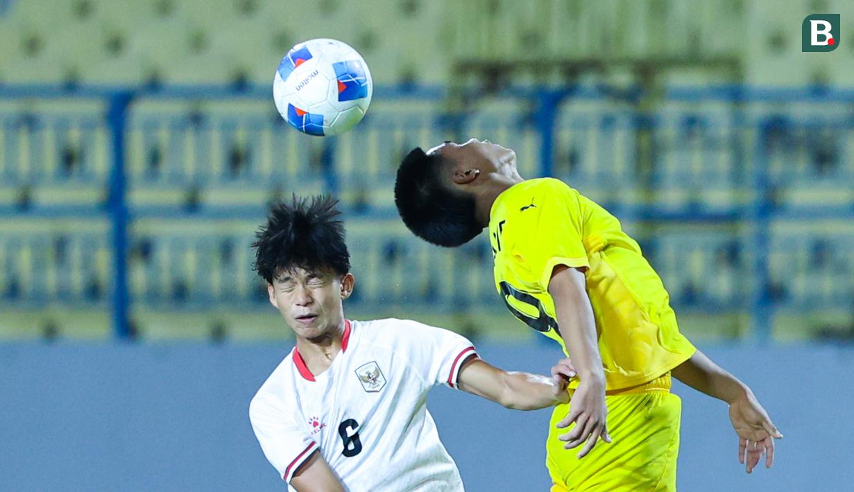 Pemain Timnas Indonesia U-17, Girly Andrade Guevara, duel udara dengan pemain Malaysia pada laga kedua Grup A Piala AFF U-17 2026 di Stadion Gelora Joko Samudro, Gresik, Jawa Timur, Kamis (16/4/2026) malam. (Bola.com/M Iqbal Ichsan)