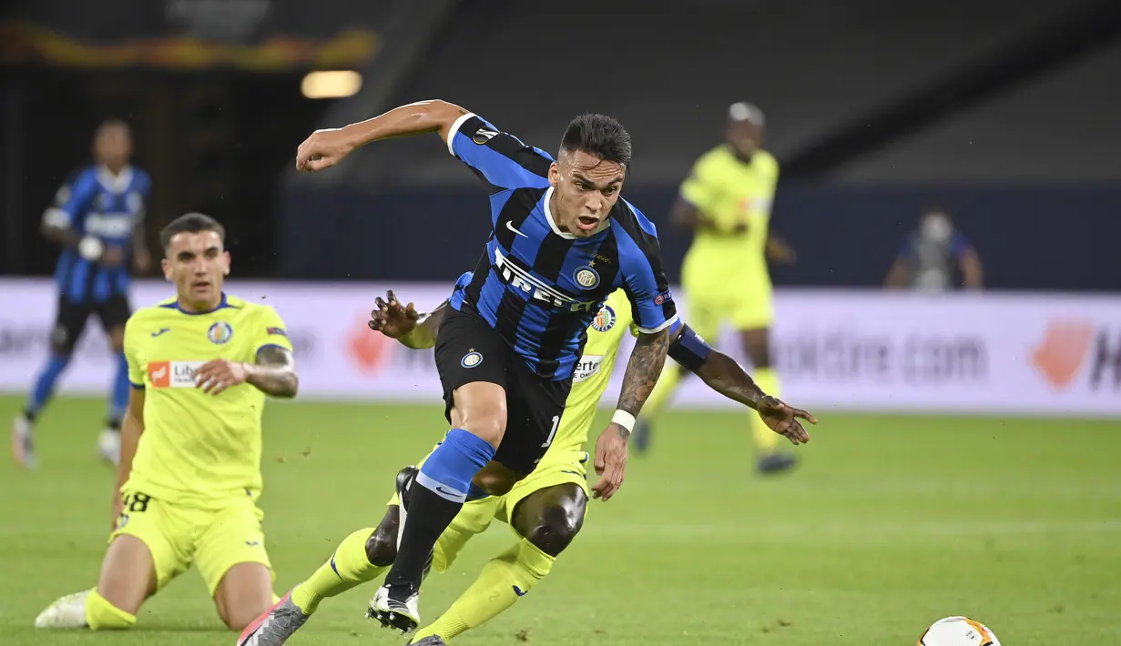 Penyerang Inter Milan, Lautaro Martinez membawa bola dari kawalan pemain Getafe, Djene Dakonam pada pertandingan babak 16 besar Liga Europa di Veltins-Arena di Gelsenkirchen, Jerman, Rabu, (5/8/2020). Inter menang 2-0 atas Getafe dan melaju ke perempat final.  (AP Photo/Ina Fassbender)