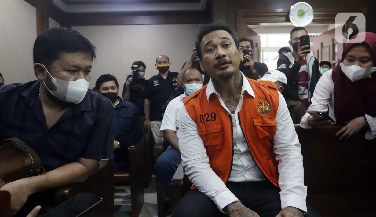 Musisi I Gede Ari Aryastina alias Jerinx (kanan) bersiap menjalani sidang kasus dugaan pengancaman di Pengadilan Negeri Jakarta Pusat, Rabu (12/1/2022). Sidang beragendakan mendengar keterangan saksi, Adam Deni dan Elsya Rosana. (Liputan6.com/Helmi Fithriansyah)