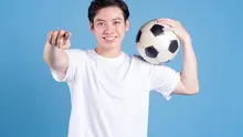 Seorang pria memegang bola di pundak sembari menunjuk ke arah kamera. (depositphotos.com/havucvp@gmail.com)