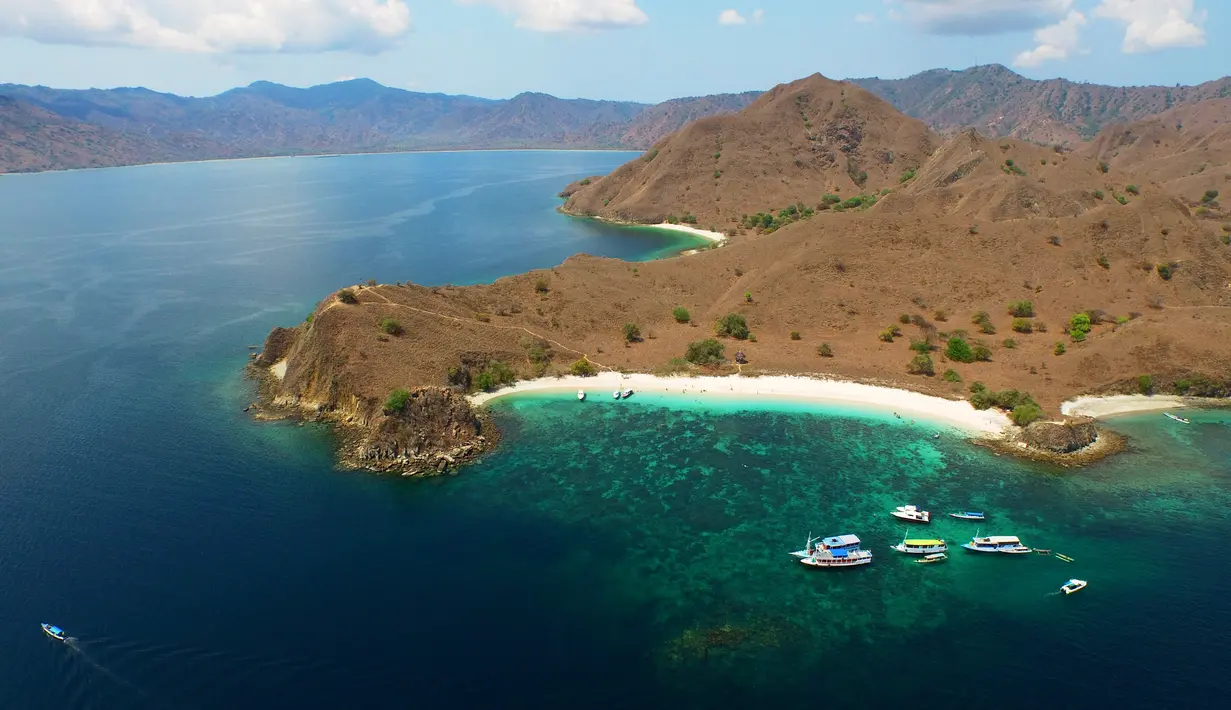 Pasir pantai yang berwarna merah jambu berasal dari batuan koral yang hancur di lautan. Versi lain mengatakan, warna merah jambu berasal dari hewan mikroskopik bernama foraminifera. (Liputan6.com/ M Husni Mubarok).