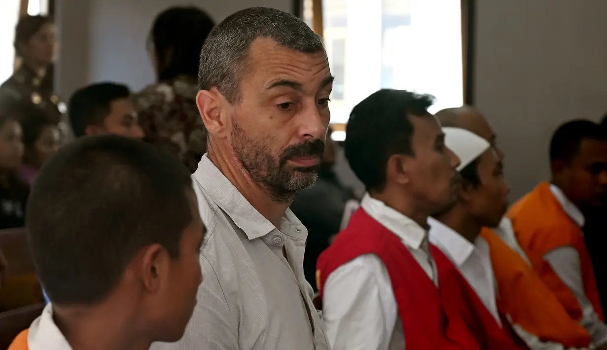 Warga negara Prancis, Samuel Pierre Danguny (kedua kiri) menunggu untuk menjalani sidang di Pengadilan Negeri Denpasar, Bali, Kamis (1/8/2019). Pierre diamankan pada 15 Maret 2019 dengan barang bukti berupa 6 paket ganja, 2 paket hasis, dan 1 paket sabu.  (SONNY TUMBELAKA/AFP)
