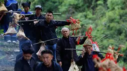 Orang-orang dari etnis minoritas Miao membawa persembahan ketika mereka menghadiri upacara pengorbanan untuk dewa gunung di Jianhe di provinsi Guizhou barat daya China (15/4). (AFP Photo/China Out)