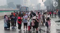 Warga berolahraga saat CFD di kawasan Bundaran HI, Jakarta, Minggu (3/7/2022). Meski sempat diguyur hujan tidak menyurutkan  masyarak untuk berolahraga di akhir pekan. (Liputan6.com/Angga Yuniar)