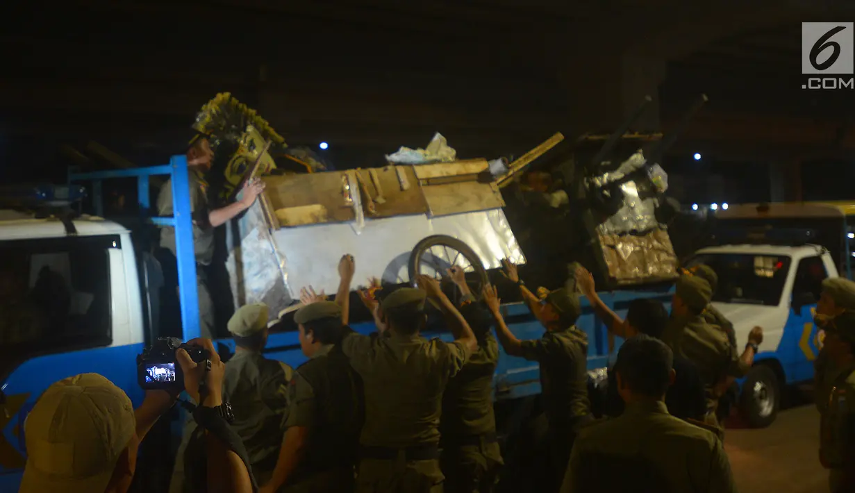 Sejumlah gerobak pemulung diangkut ke dalam mobil petugas saat razia di kawasan Duren Sawit, Jakarta, Jumat (25/5).  Razia tersebut terus dilakukan selama bulan suci Ramadan 1439 Hijriyah. (Merdeka.com/Imam Buhori)
