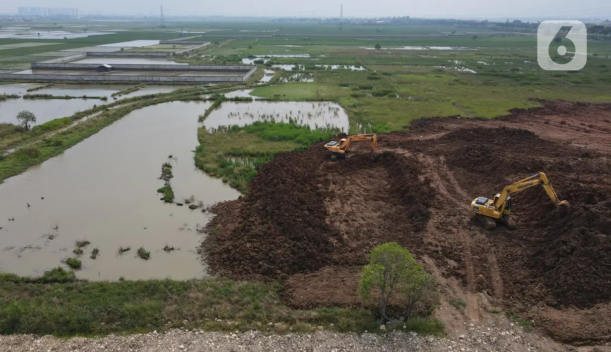 Pantauan udara menunjukkan pekerja dibantu alat berat menyiapkan lahan untuk lokasi pemakaman khusus Covid-19 di Rorotan, Jakarta Utara, Kamis (3/6/2021). Sejak mulai dibuka pada akhir Maret lalu, TPU ini diutamakan melayani pemakaman bagi jenazah Covid-19 yang ber-KTP DKI. (merdeka.com/Imam Buhori)