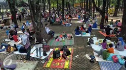 Sebagian pengunjung berkumpul di bawah rimbun pepohonan, Ragunan, Jakarta, Jumat (6/5). Mereka menggelar tikar seraya menikmati bekal makanan yang mereka bawa. (Liputan6.com/Helmi Afandi)