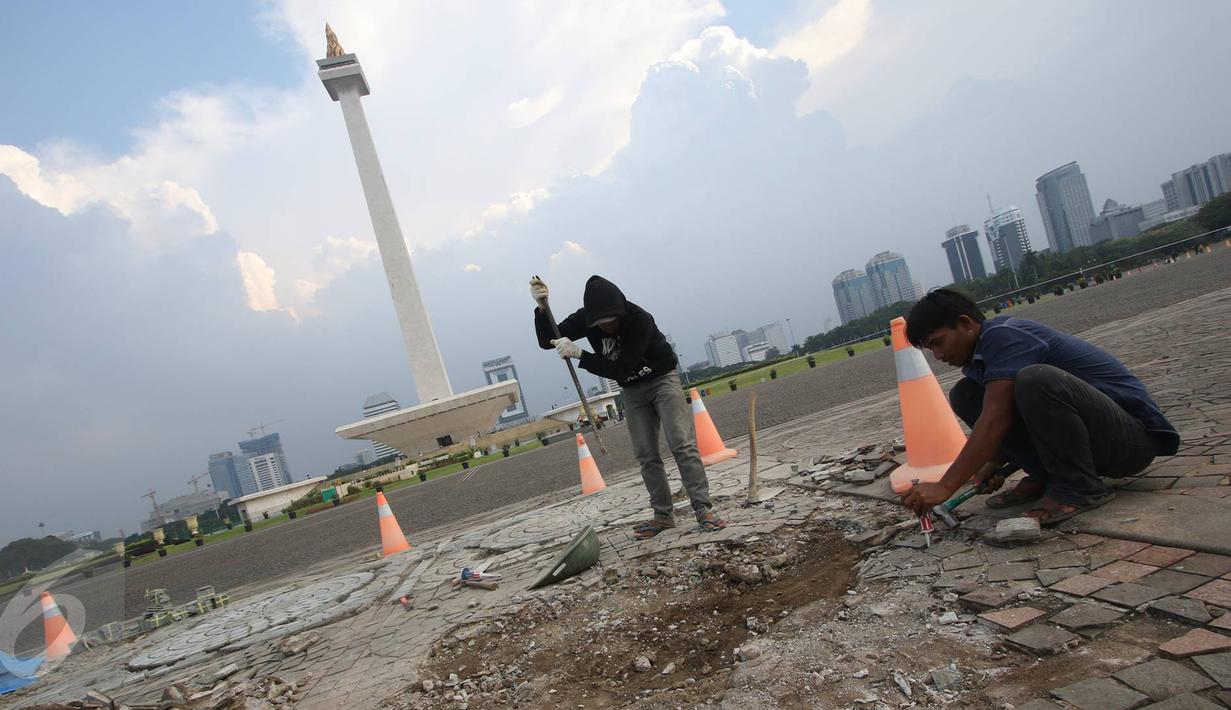 Para pekerja mengganti batu pelataran yang rusak di kawasan Monas, Jakarta, Kamis (10/11). Hal tersebut dilakukan untuk menjaga kawasan Monas agar tetap terawat dan nyaman bagi pengunjung. (Liputan6.com/Immanuel Antonius)