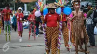 Seorang anak mengenakan pakaian adat saat meramaikan pemecahan rekor dunia egrang dalam rangkaian TAFISA World Games 2016 di Kemayoran, Jakarta, Sabtu (8/10). Pemecahan rekor dunia ini diikuti 2.016 anak SD dan SMP se-DKI. (Liputan6.com/Faizal Fanani)