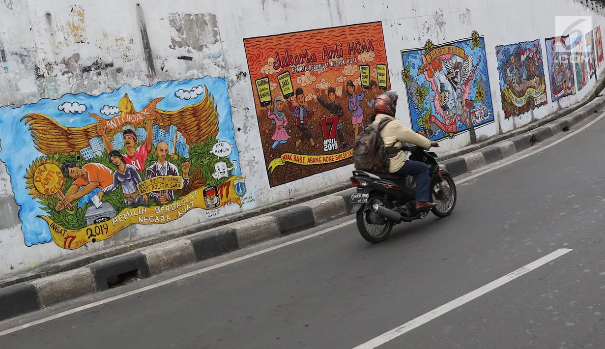 Kendaraan melintasi mural bertema Pemilu 2019 di kawasan Dukuh Atas, Jakarta, Senin (1/4). Mural-mural tersebut dibuat dalam rangka menyukseskan Pemilu yang akan berlangsung pada 17 April 2019 mendatang. (Liputan6.com/Immanuel Antonius)