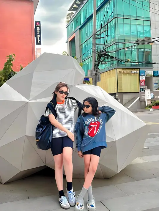 Lihat kerennya gaya ibu-anak antara Ayu Ting Ting dan Bilqis di foto ini. Ayu Ting Ting tampil dengan kaus bergaris hitam-putih dengan bagian kerah berwarna merah, dipadu legging pendek berwarna hitam. Sedangkan Bilqis tampil dengan sweater bernuansa biru dan legging pendek hitam. Keduanya tampil semakin keren dengan sunglasses. [Foto: Instagram/ayutingting92]