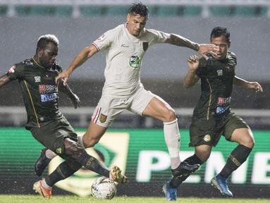 Striker Persela Lamongan, Alex Dos Santos, menghindari gelandang Tira Persikabo, Essengue Parfait, pada laga Liga 1 di Stadion Pakansari, Bogor, Senin (16/12). Kedua klub bermain imbang 1-1. (Bola.com/Vitalis Yogi Trisna)