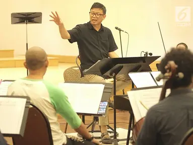 Konduktor Avip Priatna memimpin latihan Jakarta Concert Orchestra (JCO) di Balai Resital Kertanegara, Jakarta, Rabu (28/11). JCO bersiap mengadakan konser Beat It-A Tribute To Michael Jackson. (Fimela.com/Bambang Purnama)