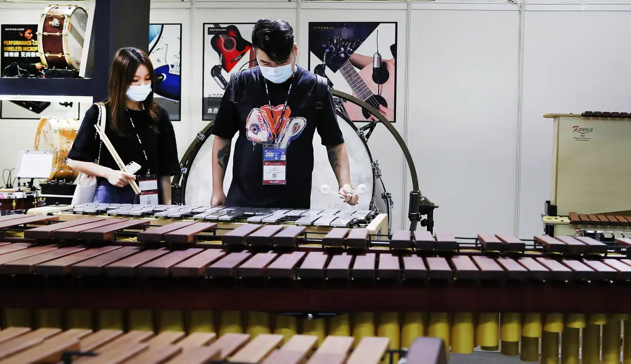 Sejumlah pengunjung menjajal alat musik perkusi pada ajang Music China 2020 di Shanghai New International Expo Center, China, 28 Oktober 2020. Pameran alat musik internasional tersebut dimulai pada 28 Oktober 2020. (Xinhua/Fang Zhe)