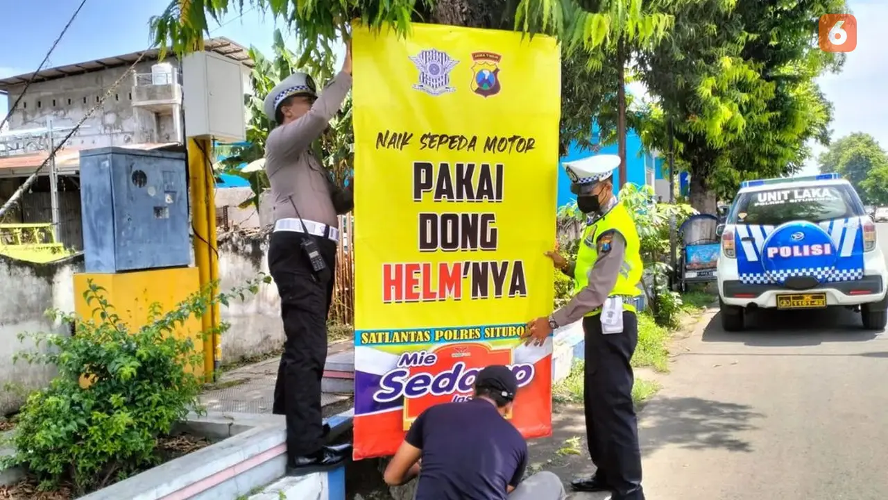 Petugas lantas Polres Situbondo mamasang papan imbauan mudik aman di jalur pantura Situbondo (Hermawan Arifianto/Liputan6.com)