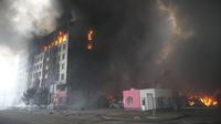 Sebuah gedung terbakar setelah penembakan di Kiev, Ukraina, Kamis (3/3/2022). Pasukan Rusia telah meningkatkan serangan mereka di kota-kota yang padat dalam apa yang disebut pemimpin Ukraina sebagai kampanye teror yang terang-terangan. (AP Photo/Efrem Lukatsky)