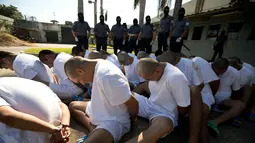 Anggota geng Mara Salvatrucha (MS-13) duduk berbaris di penjara dengan keamanan maksimal di Zacatecoluca, El Salvador (31/1). Anggota geng tersebut dipindahkan dari penjara kecil ke penjara keamanan maksimum. (AP Photo/Moises Castillo)