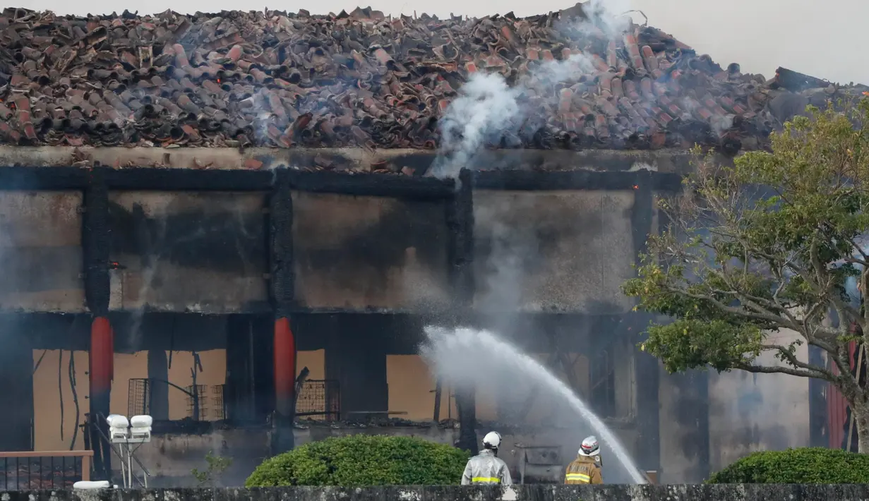 Petugas pemadam kebakaran berusaha memadamkan api yang membakar Kastil Shuri di Okinawa, Jepang selatan, Kamis (31/10/2019). Aula utama kastil yang dibangun dari kayu tersebut dilaporkan hangus tinggal rangka bangunan. (Jun Hirata/Kyodo News via AP)