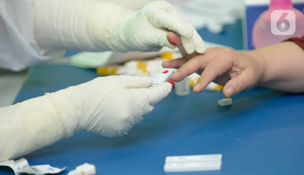 Petugas melakukan pemeriksaan cepat COVID-19 (Rapid Test) kepada tenaga pendidik SMP di SMPN 3 Ciputat, Tangerang Selatan, Kamis (27/08/2020). Rapid tes yang diikuti 400 guru mencakupi wilayah Ciputat dan Ciputat Timur itu untuk mencegah penyebaran Covid-19 di lingkungan pendidikan. (merdeka.com/Dwi
