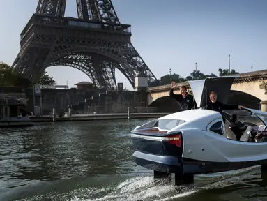 Pendiri Sea Bubbles Alain Thebault (kiri) dan Anders Bringdal (kanan) berdiri di atas kapal "flying taxi" Sea Bubble saat demonstrasi di sungai Seine di Paris, Prancis (20/5). (AFP Photo/Lionel Bonaventure)