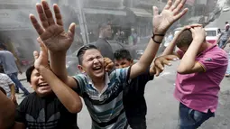 Anak-anak bersorak ketika personel dinas Kota Amman menyemprot mereka dengan sprinkler air untuk mengurangi efek dari gelombang panas di Yordania, Senin(3/8/2015). (REUTERS/Muhammad Hamed)