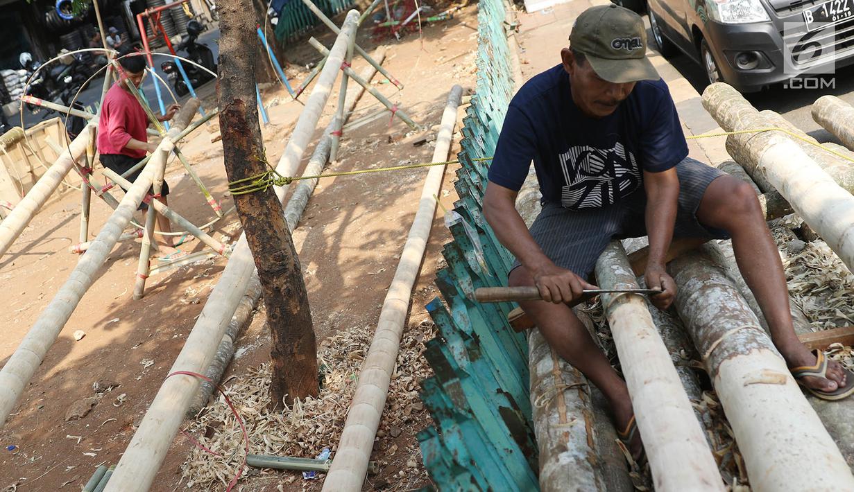 Pedagang menyerut batang pohon pinang yang dijual di kawasan Manggarai, Jakarta, Kamis (3/7). Pohon pinang tersebut dijual seharga Rp900ribu perbatang, yang banyak digunakan untuk meramaikan perlombaan perayaan HUT RI. (Liputan6.com/Immanuel Antonius)