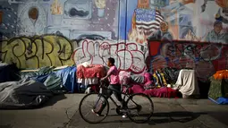 Warga berjalan melewati tenda yang ditempati kaum tunawisma di Skid Row, Los Angeles, California, Kamis (1/10/2015). Kota Los Angeles menetapkan status darurat terkait makin rumitnya persoalan kaum tunawisma di sana. (REUTERS/Lucy Nicholson)