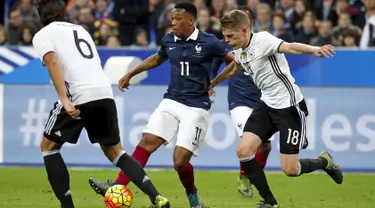 Penyerang Perancis, Anthony Martial (tengah) berusaha melewati bek Jerman, Matthias Ginter pada laga persahabatan di stadion Stade de France, Perancis, (13/11). Perancis menang atas Jerman dengan skor 2-0. (REUTERS/Benoit Tessier)