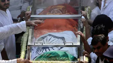 Jenazah aktris Bollywood Sridevi Kapoor dibaringkan dalam peti kaca dan berbalut bendera India saat akan dikremasi di Mumbai, India, Rabu (28/2). Ribuan penggemar berkabung dan memberi penghormatan terakhir untuk Sridevi. (AP Photo/Rajanish Kakade)
