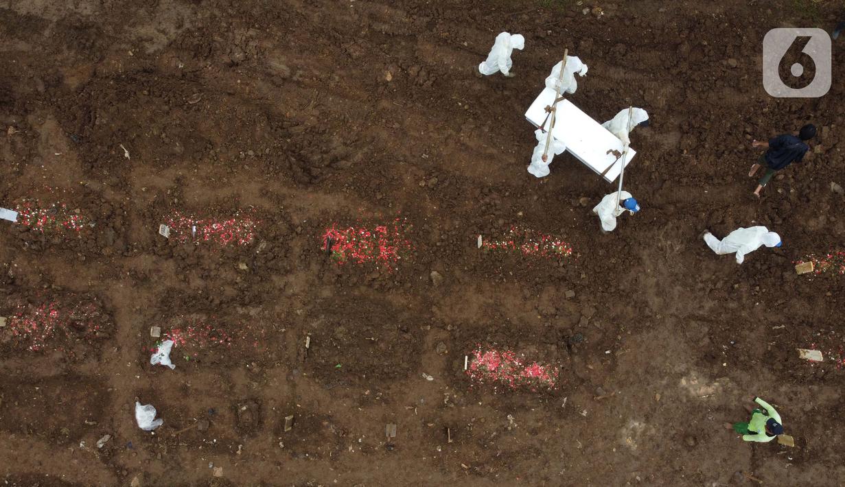 Foto udara petugas membawa peti jenazah dengan protokol COVID-19 di TPU Srengseng Sawah, Jakarta, Kamis (21/1/2021). Sebagian lahan TPU Srengseng Sawah yang dijadikan lokasi pemakaman jenazah Covid-19 sejak Selasa (12/1) lalu, kini hanya tersisa 79 petak makam. (Liputan6.com/Helmi Fithriansyah)