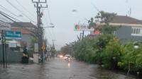 Hujan sejak semalam menyebabkan banjir di sejumlah ruas jalan dan rumah warga di Kota Denpasar, Bali, Senin pagi (6/12/2021). (Liputan6.com/ Esty)