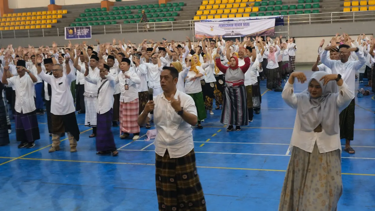 Ratusan Aparatur Sipil Negara (ASN) Pemda Garut, Jawa Barat, ambil bagian dalam pemecahan rekor Museum Rekor Dunia Indonesia (MURI) kategori pemakaian sarung tenun terbanyak di Indonesia. (Liputan6.com/Jayadi Supriadin)
