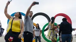 Warga berfoto di depan ring olimpiade di pantai Copacabana, Rio de Janeiro, jelang diselenggarakannya Olimpiade Rio 2016, (30/7/2016) 