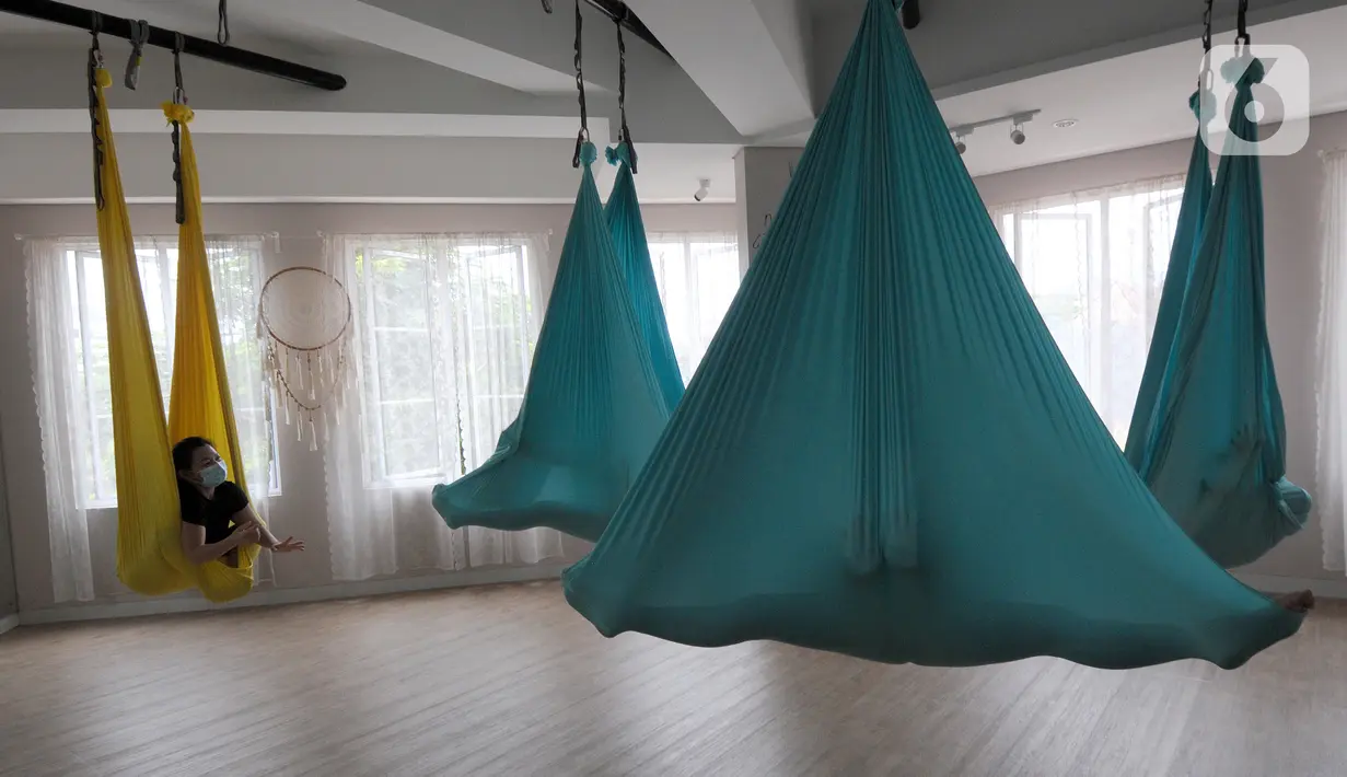 Para murid melakukan gerakan aerial yoga atau yoga udara di Aerial Jooga Studia, Kelapa Dua, Tangerang, Banten, Minggu (10/10/2021). Yoga udara menggunakan hammock atau kain yang mengapung untuk menopang berat tubuh seseorang. (merdeka.com/Arie Basuki)