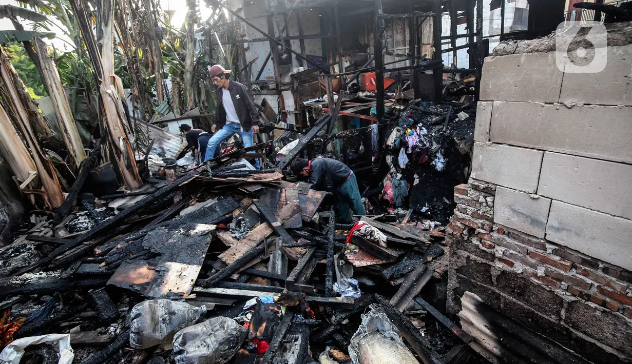 Warga memilah barang yang masih bisa diselamatkan di reruntuhan rumah akibat kebakaran yang melanda pemukiman di jalan Bojong Kavling RT 16/RW04 Kelurahan Rawa Buaya, Jakarta, Rabu (5/1/2022). Kebakaran terjadi Selasa (4/1/2022) menghanguskan setidaknya 14 rumah warga. (Liputan6.com/Johan Tallo)