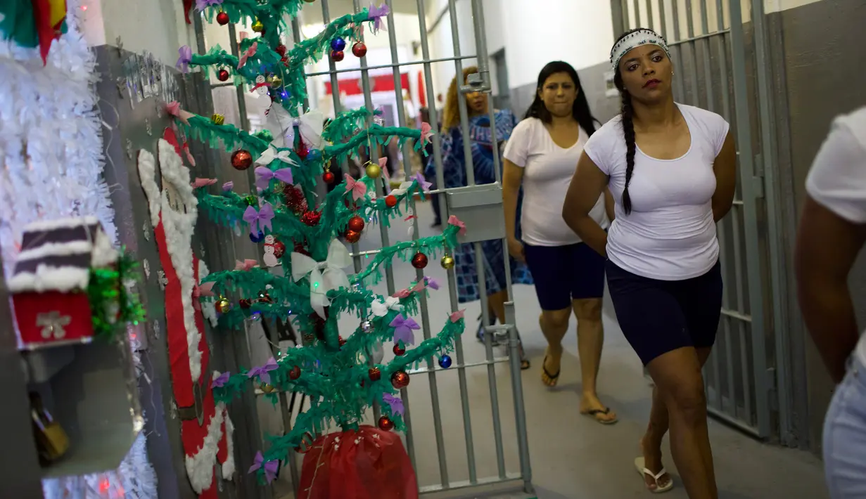 Narapidana perempuan meninggalkan sel untuk menghadiri acara tahunan menjelang  natal di Penjara Nelson Hungria, Rio de Janeiro, Kamis (13/12). Para tahanan juga menyanyikan lagu religi dan memainkan drama perjalanan hidup Yesus. (AP/Silvia Izquierdo)