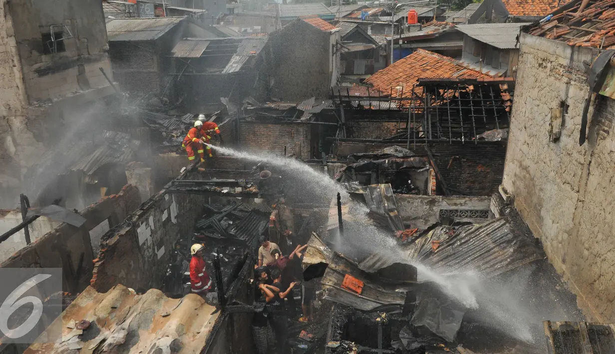 Warga membantu petugas memadamkan api saat kebakaran di Jalan Kramat Pulo Dalam RT 03 RW 08, Senen, Jakarta, Selasa (3/11/2015). Sekitar 10 rumah hangus akibat kebakaran yang terjadi. (Liputan6.com/Gempur M Surya)