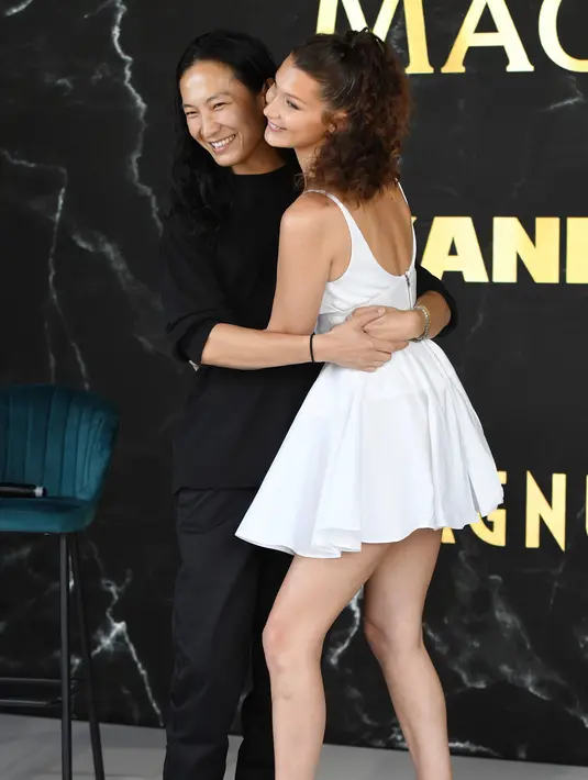 Model Bella Hadid memeluk Desainer Alexander Wang dalam acara promosi Magnum selama Festival Film Cannes KE-71, Prancis selatan (10/5). Bella Hadid tampil cantik dan seksi dengan gaun putih minim dengan kalung di lehernya. (AP Photo/Arthur Mola)