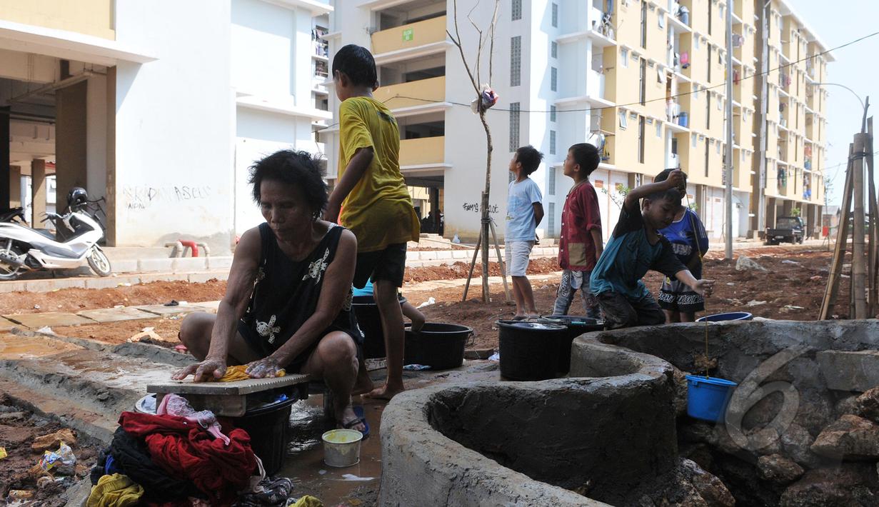 Tampak Seorang wanita sedang mencuci pakaian di halaman Rusunawa muara baru, Jakarta, Kamis (21/05/2015). Buruknya aliran air bersih membuat para penghuni Rusunawa muara baru harus mengambil air di sumur. (Liputan6.com/Herman Zakharia)