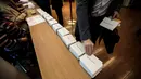 Warga Prancis mengambil surat suara saat mengikuti pemilihan presiden Prancis putaran pertama di Tokyo, Jepang (23/4). Pemilihan ini merupakan pemilihan umum presiden kesebelas pada masa Republik Kelima Perancis. (AFP/Behrouz Mehri)