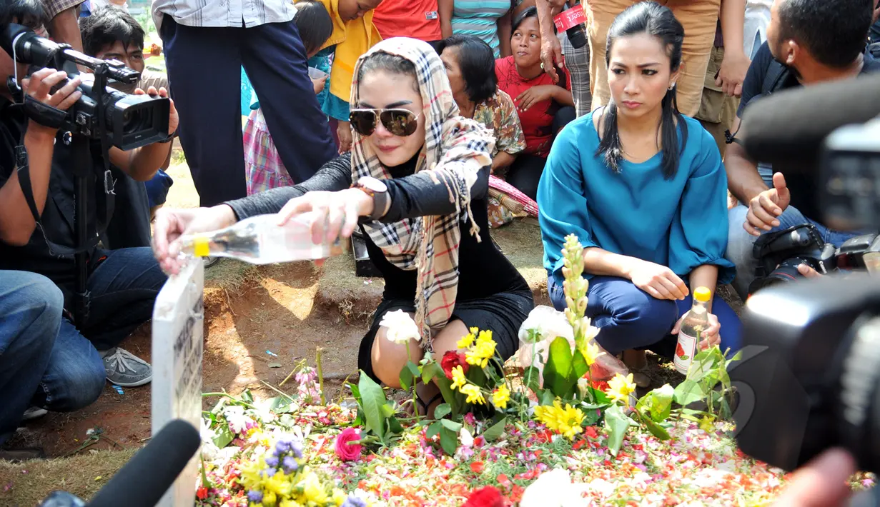Nikita Mirzani saat menyiram air mawar di pusara Olga Syahputra di TPU Malaka seusai bebas dari Rutan  Bambu pagi tadi, Jakarta, Senin (30/3/2015). (Liputan6.com/Panji Diksana)