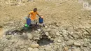 Warga mengambil air pada lubang di aliran Sungai Cipamingkis yang kering, Cibarusah, Bekasi, Jabar, Kamis (2/8). Dua bulan tak diguyur hujan menyebabkan warga perbatasan Bogor-Bekasi dilanda kekeringan dan kesulitan air bersih. (Merdeka.com/Arie Basuki)