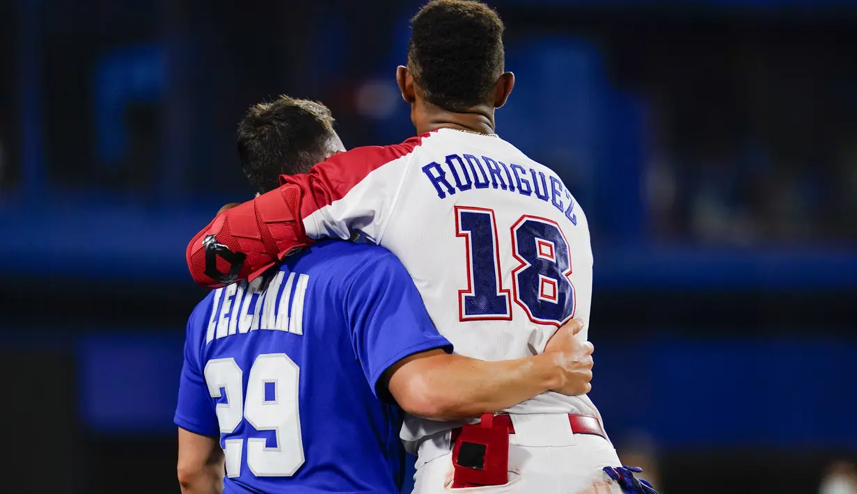 Atlet Israel Alon Leichman (kiri) dan atlet Republik Dominika Julio Rodriguez berpelukan usai pertandingan bisbol Olimpiade Tokyo 2020 di Yokohama, Jepang, 3 Agustus 2021. Republik Dominika menang 7-6. (AP Photo/Matt Slocum)