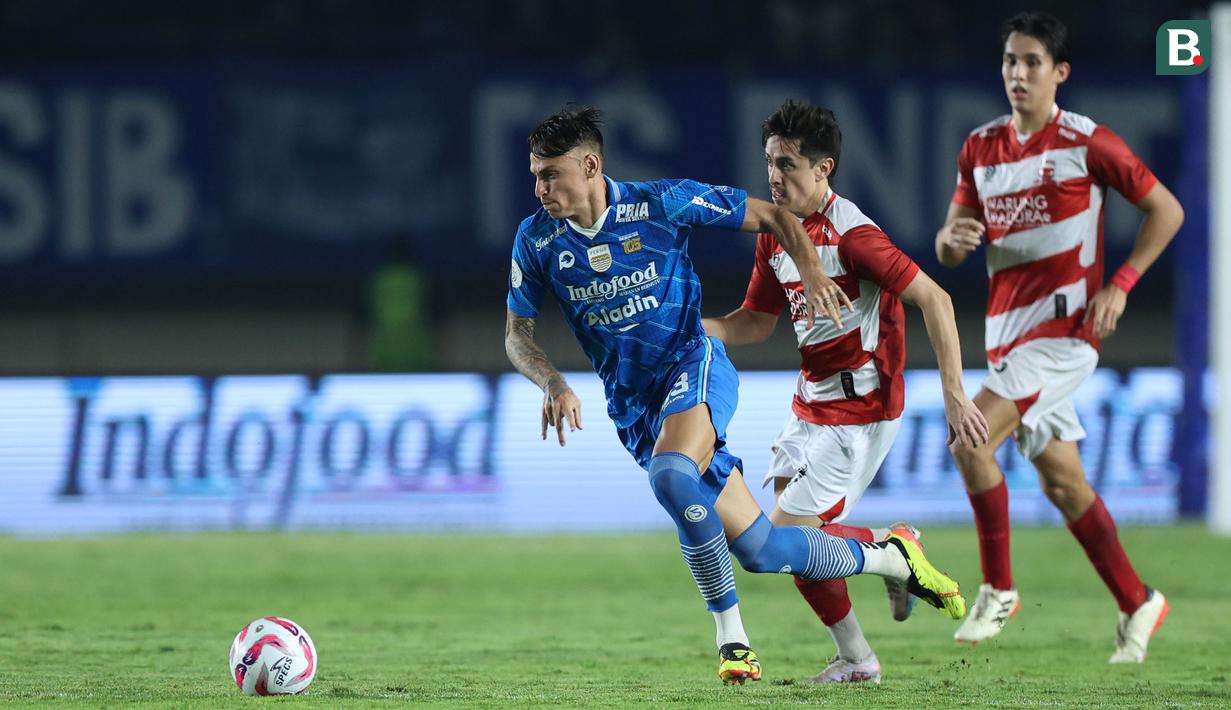 <p>Pemain Persib Bandung, Stefano Beltrame (kiri) menggiring bola melewati pemain Madura United pada laga leg 1 final Championship Series BRI Liga 1 2023/2024 antara Persib Bandung melawan Madura United di Stadion Si Jalak Harupat, Bandung, Minggu (26/05/2024). (Bola.com/M Iqbal Ichsan)</p>