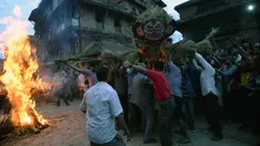 Para lelaki Nepal membawa patung jerami iblis Ghantakarna untuk dibakar dalam festival Ghantakarna di kota kuno Bhaktapur, Nepal (30/7/2019). Festival Hindu ini juga dikenal dengan nama Gathemangal. (AFP Photo/Prakash Mathema)