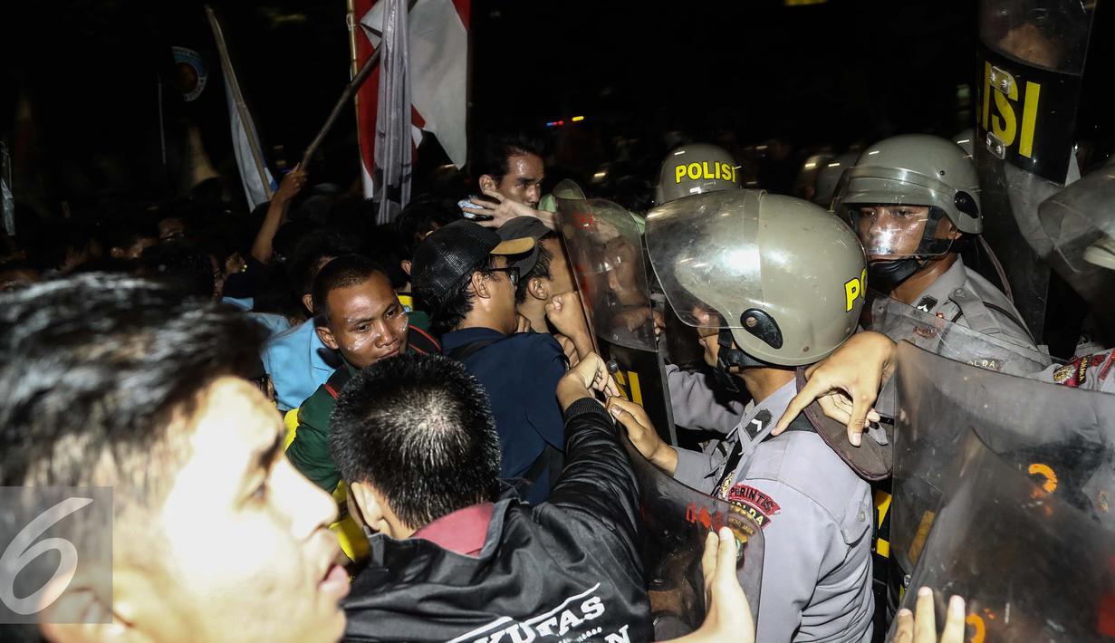 Massa aksi terlibat bentrok dengan polisi yang berjaga saat menggelar aksi unjuk rasa di depan Istana Negara, Kamis (12/1). Dalam aksinya mereka menuntut Presiden Jokowi-JK untuk membuat kebijakan yang pro terhadap rakyat. (Liputan6.com/Faizal Fanani)