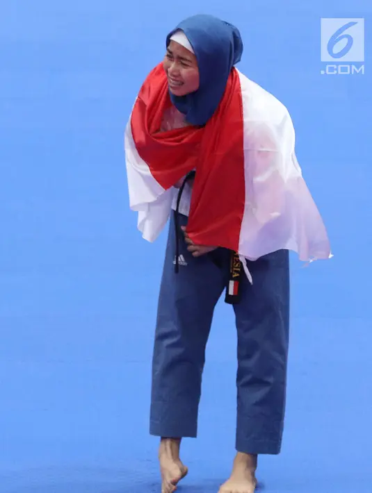 Atlet Taekwondo putri Indonesia, Defia Rosmaniar saat merayakan kemenangan atas Salahshouri Marjan (Iran) pada Final Women Individual Poomsae di JCC, Jakarta, Minggu (19/8). (Liputan6.com/Helmi Fithriansyah)
