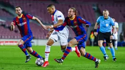 Pemain Paris Saint-Germain Kylian Mbappe (tengah) memperebutkan bola dengan pemain Barcelona Oscar Mingueza pada leg pertama babak 16 besar Liga Champions di Camp Nou, Barcelona, Spanyol, Selasa (16/2/2021). PSG menang 4-1. (AP Photo/Joan Monfort)