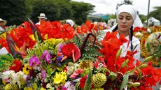 Seorang petani menyiapkan rangkaian bunga yang dikenal sebagai "silleta" sebelum mengikuti parade tradisional Silleteros, yang diadakan sebagai bagian dari Festival Bunga, di Medellin, Kolombia, pada 7 Agustus 2023. (AFP/Fredy Builes)